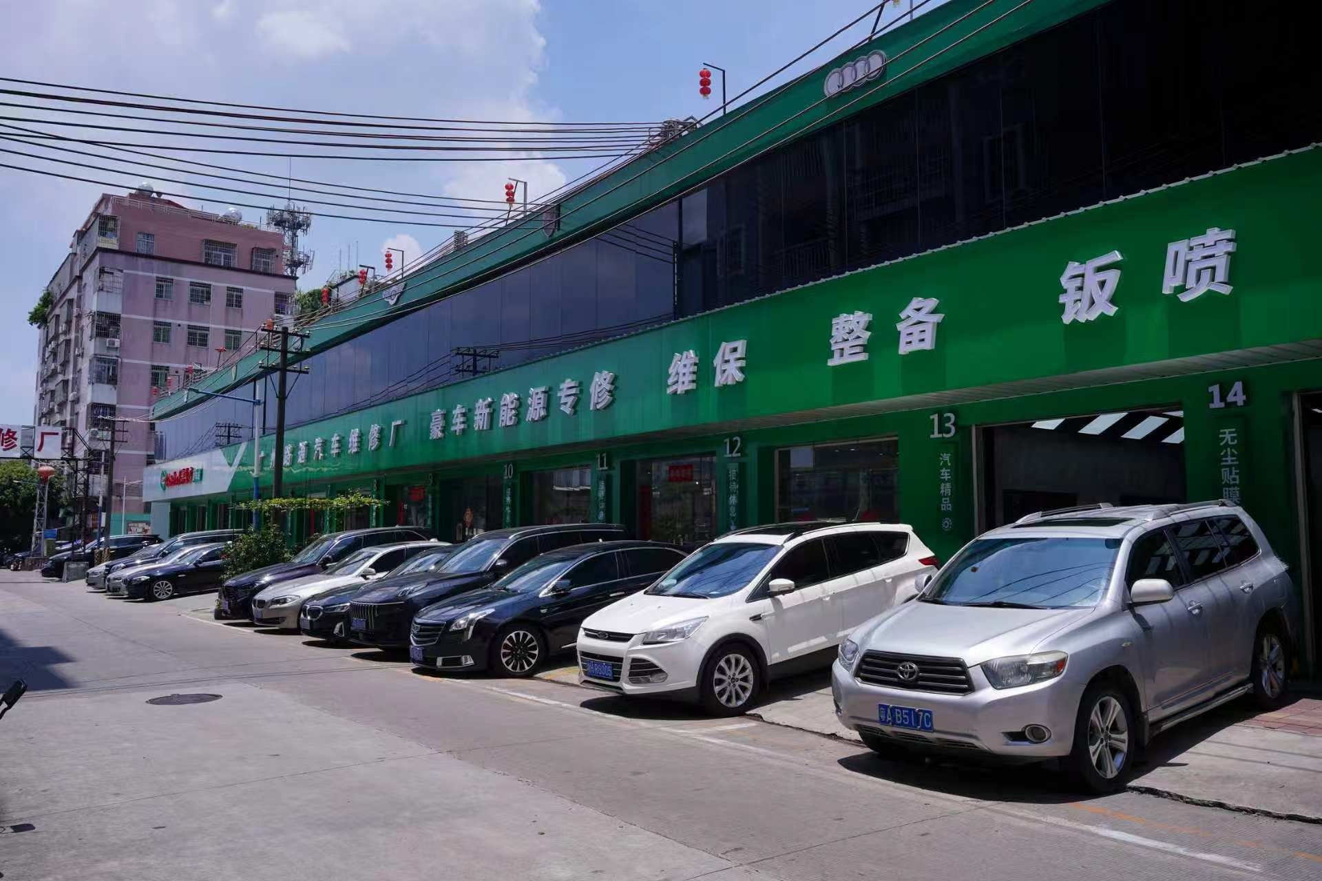 路通维修厂门店外观，绿色招牌与门前车辆